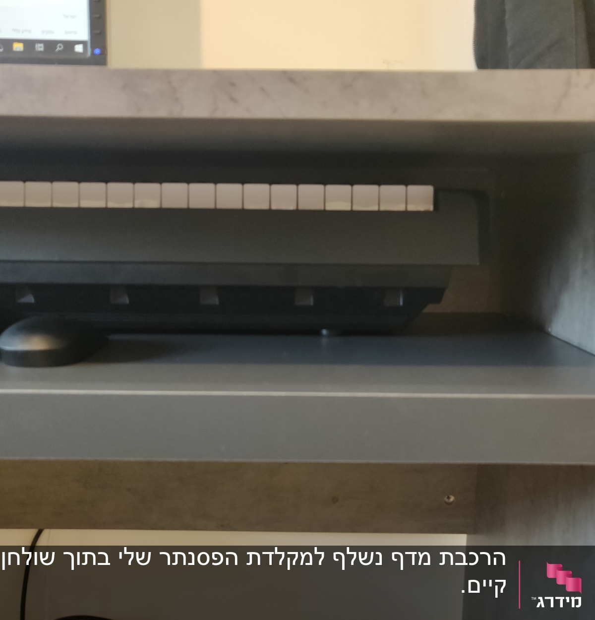 מקלדת על מדף עץ מתחת לשולחן